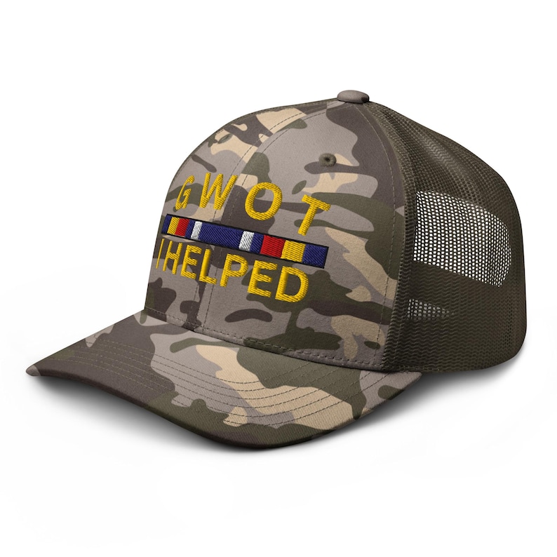 May include: Camouflage baseball cap with a mesh back. The front of the cap features the embroidered text "GWOT HELPED" in yellow, with a ribbon design above the text. The cap's colors include shades of green, brown, and tan.