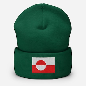 以下が含まれることがあります： 折り返しのある濃い緑色のビーニー帽。帽子には、赤い背景に白い円が含まれるグリーンランドの国旗の刺繍パッチが付いています。