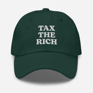 Könnte beinhalten: Dunkelgrüne Baseballkappe mit dem gestickten Text "TAX THE RICH" in Weiß. Die Kappe hat einen gebogenen Schirm und einen verstellbaren Riemen. Ein auffälliges Modeaccessoire.