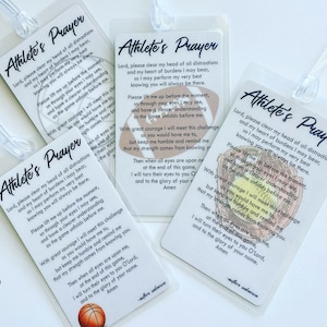 May include: Four rectangular plastic luggage tags featuring the Athlete's Prayer text in black script and print. Each tag displays a different sports ball graphic: a basketball, a football, a baseball glove with a ball, and a volleyball.