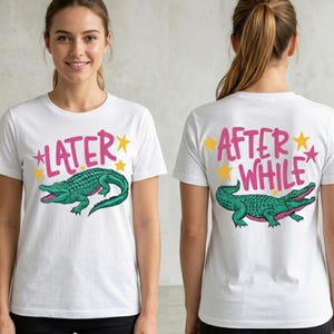 May include: White t-shirt featuring a green alligator graphic with the text "LATER" in pink on the front and "AFTER WHILE" on the back. The design includes yellow stars. The shirt is a casual style.