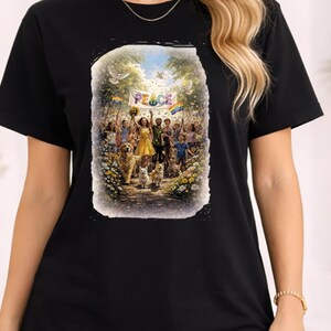 Może przedstawiać: Czarny t-shirt z kolorową grafiką przedstawiającą tłum ludzi i psów trzymających transparent z napisem "PEACE". Obraz ma styl vintage, malowany z gołębiami i tęczową flagą.