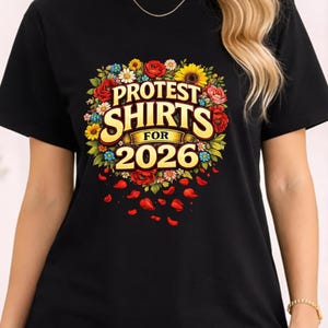 Może przedstawiać: Czarny t-shirt z kwiatowym wzorem i napisem "PROTEST SHIRTS FOR 2026". Projekt zawiera czerwone róże, żółte słoneczniki i inne kwiaty. Kształty czerwonych płatków są rozrzucone wokół kwiatowego wzoru.