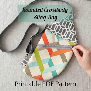 May include: A rounded crossbody sling bag with a geometric pattern in orange, green, and blue. The bag has a gray strap and zipper, with the text "Rounded Crossbody Sling Bag" and "Printable PDF Pattern".