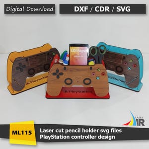 May include: Laser-cut wooden pencil holders in the shape of PlayStation controllers. The holders are in brown, yellow, and blue, with the text "PlayStation" visible. The image also includes the text "Digital Download" and "DXF / CDR / SVG".