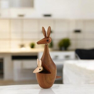 May include: A wooden kangaroo figurine with a joey in its pouch. The kangaroo is brown and the joey is light brown. The figurine is made of wood and has a smooth finish.