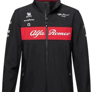 May include: Black jacket with a red horizontal stripe across the chest, featuring the Alfa Romeo logo in white. The jacket has a high collar, a full-length zipper, and various sponsor logos. The jacket is designed for the Alfa Romeo F1 team.