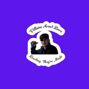 May include: A sticker with a purple background featuring a man wearing a black hat and jacket. The sticker has the text "Villains Aren't Born Darling, They're Made" in a white, cursive font.