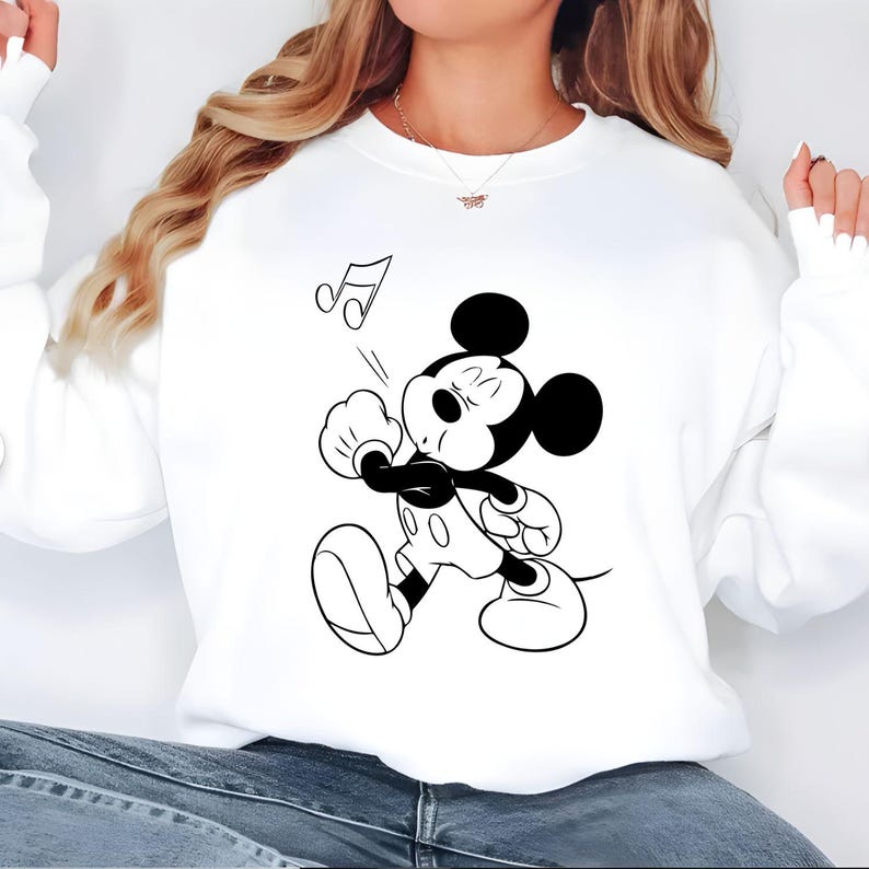 Puede incluir: Sudadera blanca con una ilustraci&oacute;n en blanco y negro de Mickey Mouse cantando. Mickey tiene los ojos cerrados y una nota musical sobre su cabeza. La sudadera es de estilo casual.