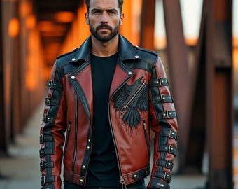 May include: A two-tone leather jacket in black and reddish-brown with a raven graphic on the front. The jacket features multiple buckles on the sleeves and a black collar. The model is wearing a black t-shirt and black jeans.