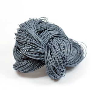 May include: A close-up of a gray, twisted ball of twine. The twine is made of natural fibers and has a rough texture.