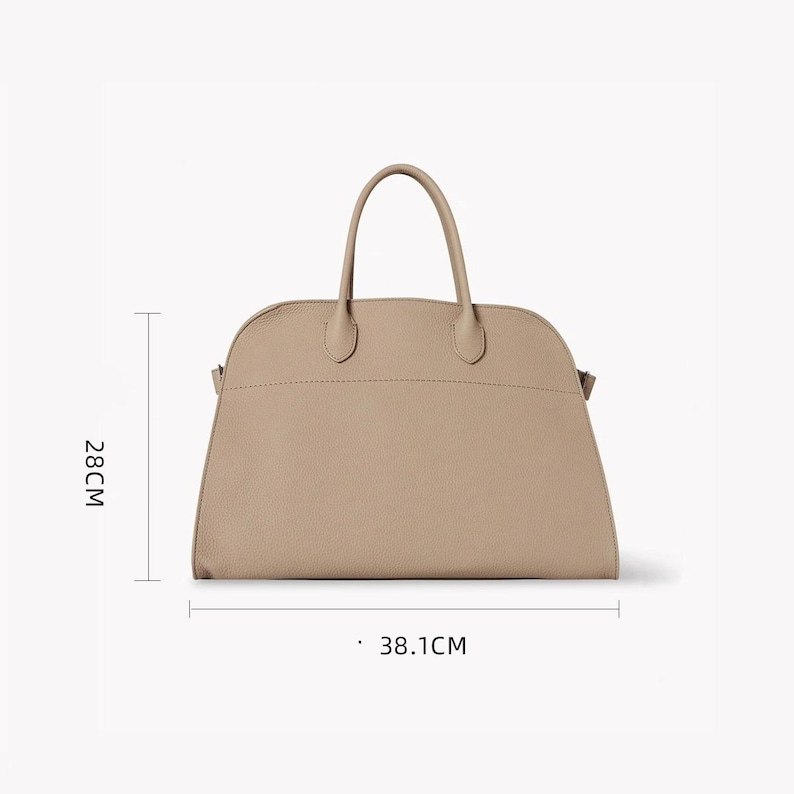 Puede incluir: Bolso de mano beige con dos asas y una parte superior curvada. El bolso mide 28 cm de alto y 38,1 cm de ancho. El bolso tiene un dise&ntilde;o sencillo y elegante.