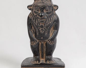 Estatua del antiguo Egipto de Bes, un dios menor del antiguo Egipto, representado como un enano con cabeza grande, hecha de piedra negra pesada en Egipto.