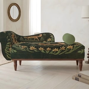 May include: A dark green chaise lounge with a botanical and fox pattern. The chaise has a curved back and wooden legs. A green oval pillow rests on the seat. The room also features a floor lamp, a vase with dried flowers, and a round mirror.