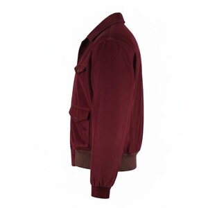 May include: A burgundy corduroy jacket with a classic collar and two front pockets. The jacket features a brown ribbed hem and cuffs. This casual jacket is a stylish outerwear option.