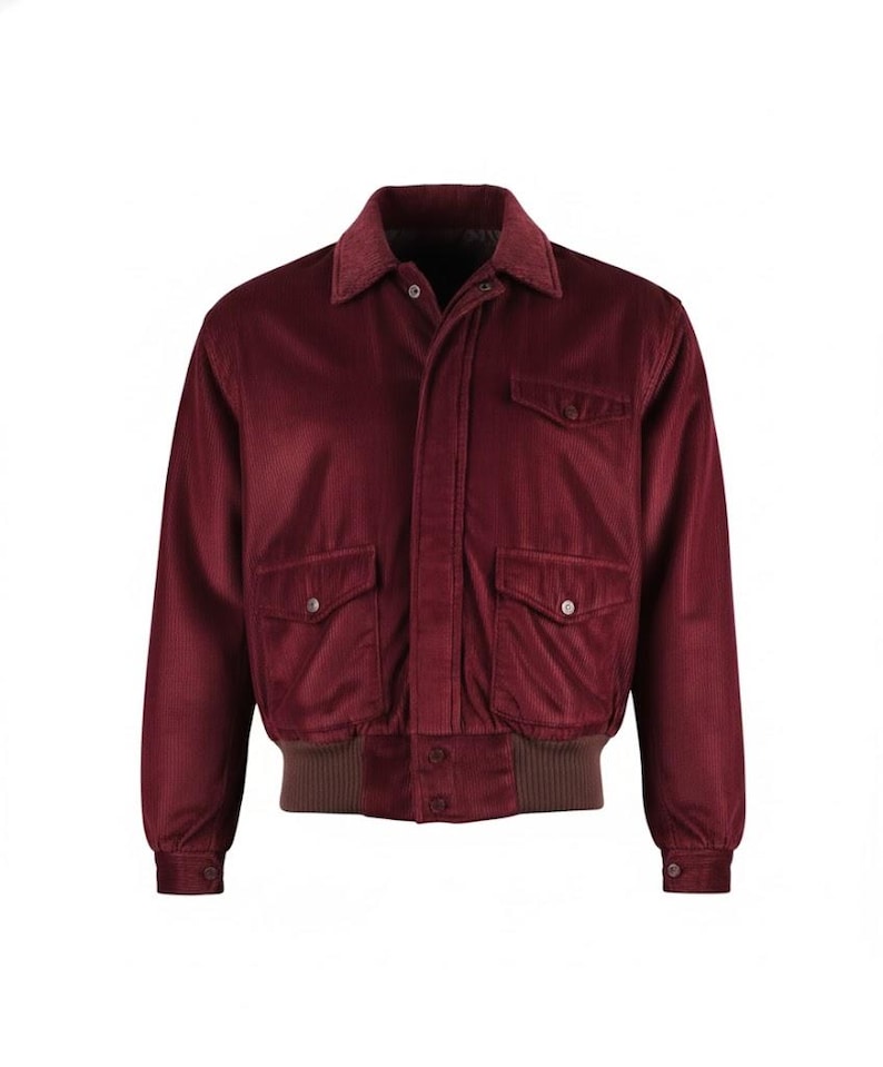 May include: A burgundy corduroy jacket with a brown collar and cuffs. The jacket has two front pockets with button closures and a button-up front. The jacket has a classic bomber style.
