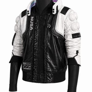 May include: A black and white jacket featuring a high collar with iridescent trim, white shoulder pads with circular accents, and the text NUSA printed vertically on the chest. The garment includes a front zipper, black sleeves, and rectangular patches.