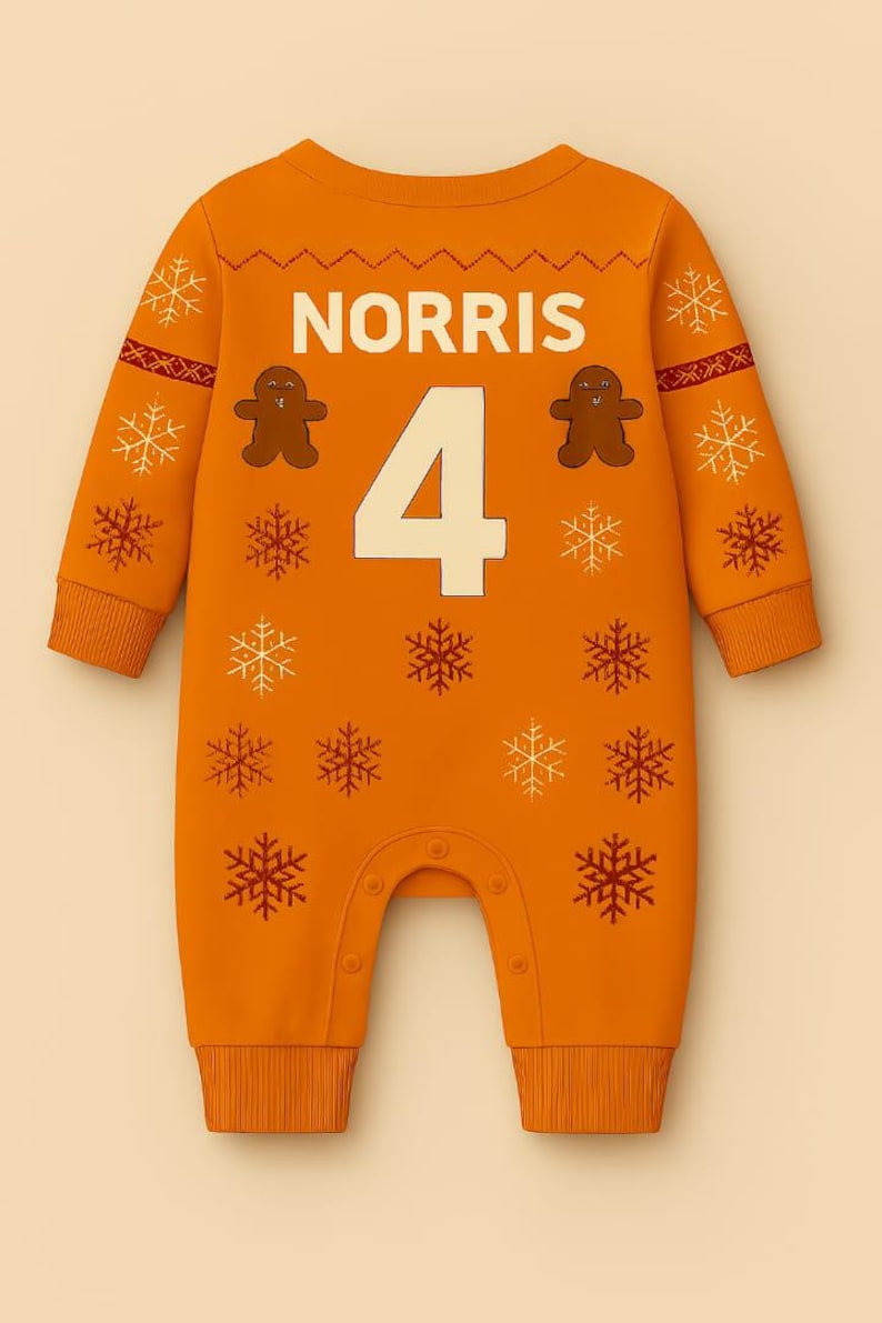 May include: Orange baby jumpsuit with the name "NORRIS" and the number "4" in white. Features gingerbread man and snowflake designs in brown and white. The jumpsuit has long sleeves and snaps at the bottom.