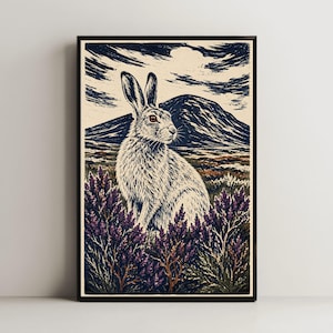 May include: A framed art print featuring a detailed illustration of a hare sitting in a field of purple heather. The background displays a dark, textured mountain landscape under a cloudy sky, rendered in a woodcut style with cream and dark blue tones.