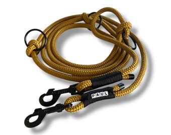 May include: A yellow rope dog leash with two black metal clips and a black tag that says "PAUL".