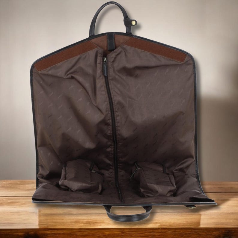 Foldable leather suit garment bag with customized initials, crafted for stylish men who travel with suits – fits easily in carry-on compartments, protects clothing, and makes a unique gift for groom or husband.