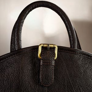 Travel-ready hanging leather suit bag with personalized options, designed for businessmen, grooms, and professionals – protects garments from wrinkles and offers elegant functionality on the go.