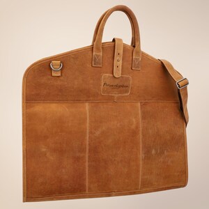 Rustic leather garment bag with zipper closure, reinforced stitching, and spacious interior – perfect for weddings, groomsmen, and business travel.