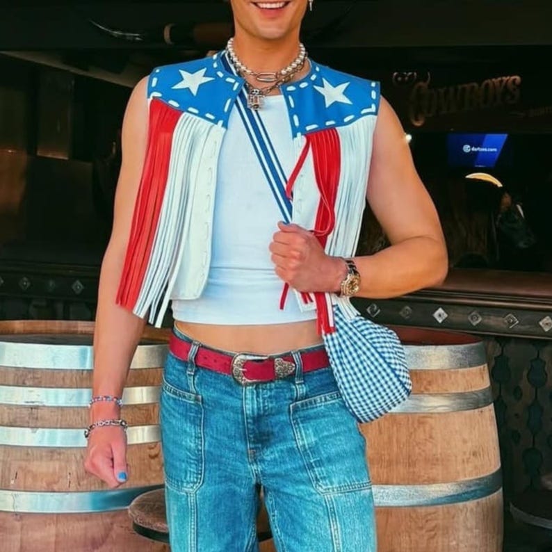 Unisex American Flag leather fringe vest, handmade patriotic festival jacket, genuine leather cowboy vest, custom Western wear for men and women, rustic vintage leather vest for country concerts and events.