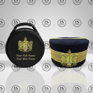 Puede incluir: Maleta redonda negra y sombrero azul marino, ambos con emblemas bordados en oro. La maleta tiene un asa y el texto "Your Full Name, Your Rite Name". El sombrero tiene una banda y ribetes dorados.