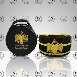 Puede incluir: Sombrerera redonda y negra y gorra con diseños dorados bordados de águilas y cruces. La sombrerera tiene un asa y el texto "Your Full Name, Your Rite Name". La gorra tiene un ribete dorado y el número 32.