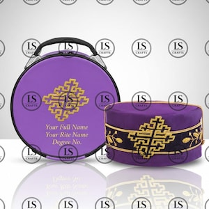 Op de afbeelding: Een paarse ceremoniële hoed en bijpassende ronde koffer. De hoed heeft gouden borduursels en een zwarte band. De koffer heeft een handvat en een gouden kruisontwerp, met de tekst "Your Full Name, Your Rite Name, Degree No."