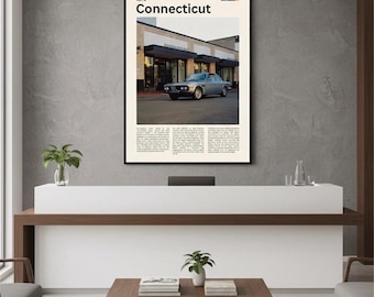 May include: A framed poster with the word "Connecticut" at the top, showing a silver car parked outside a building. The poster has text below the image. The poster is displayed on a grey wall.