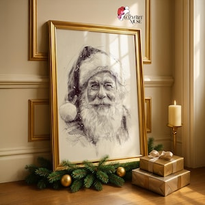 May include: A framed pen and ink drawing of Santa Claus with a white beard and hat. The artwork is in a gold frame, propped against a wall. A lit candle, wrapped gifts, and greenery with gold ornaments are in the foreground.