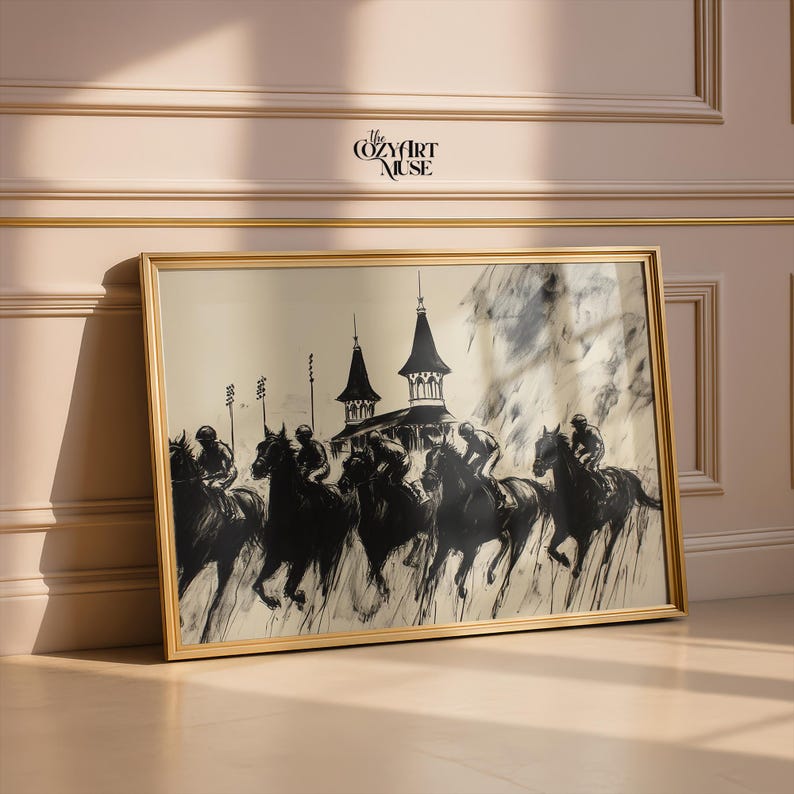 May include: Framed black and white artwork depicting a horse race with jockeys. The print features a vintage style with a gold frame. The artwork is displayed against a neutral wall.