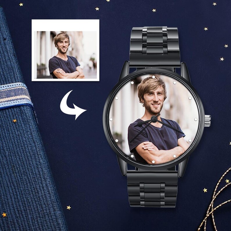 Op de afbeelding: Zwarte polshorloge met een foto van een man op de wijzerplaat. Het horloge heeft een zwarte metalen band en een ronde wijzerplaat met kleine witte markeringen. Een kleinere foto van de man staat in de linkerbovenhoek.