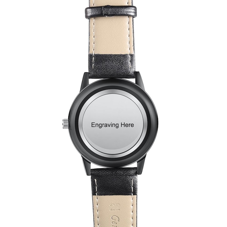 Puede incluir: Reloj de pulsera negro con bisel negro y esfera clara con la inscripci&oacute;n "Engraving Here". El reloj tiene una correa de cuero negro con la parte inferior de color claro. Dise&ntilde;o cl&aacute;sico.