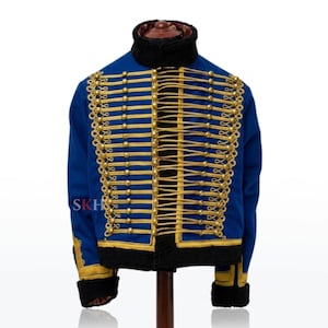 May include: A royal blue jacket featuring a high black collar and black cuffs. The front is adorned with horizontal gold braided cord detailing and gold-toned buttons arranged in vertical rows. The text SKH is visible on the left side.