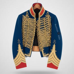 May include: A blue military jacket with gold rope detailing and red accents. The jacket has a high collar and is adorned with gold buttons and trim. The sleeves feature gold embroidery and the text "Scottish Kilts".