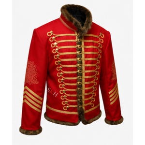 May include: A bright red jacket featuring gold braided cord detailing across the front, a high collar, and cuffs trimmed with brown faux fur. The sleeves display gold embroidered patterns and horizontal stripes, with the letters SKH visible.