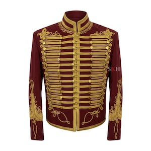May include: A deep maroon military-style jacket featuring a high collar and extensive gold braided cord detailing across the front. The garment includes rows of gold buttons and intricate gold embroidery on the sleeves. The text SKH is visible.