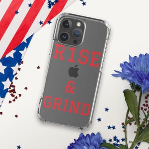 Puede incluir: Una funda transparente para teléfono con fondo gris y las palabras "RISE & GRIND" en rojo.
