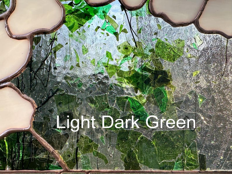 May include: A stained glass panel featuring a mosaic of light and dark green glass shards encased in copper foil solder lines, with opaque cream-colored glass borders. The text Light Dark Green is printed in white across the center.