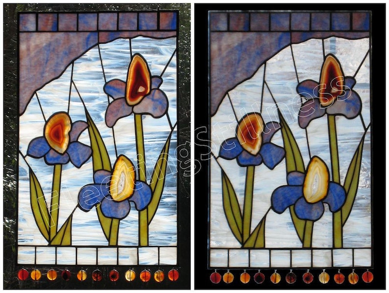 May include: Two stained glass panels featuring a design of three blue irises with agate centers. The background is a light blue with a white, cloudy pattern. The panels are framed in black.