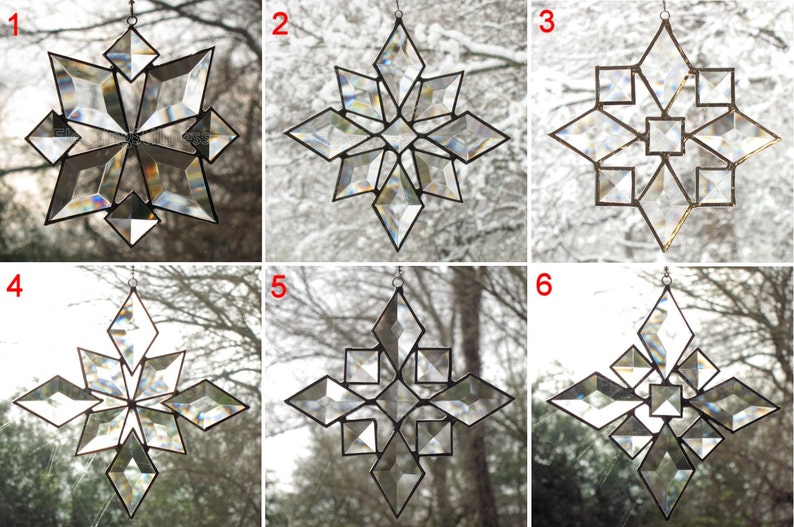 May include: Six clear glass snowflake ornaments with a geometric design. Each snowflake is suspended from a silver string and is hanging in front of a window.