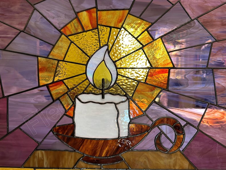 K&ouml;nnte beinhalten: Buntglasfenster mit einer brennenden Kerze in einem Halter. Die Kerze ist wei&szlig; mit einer gelben Flamme, vor einem Hintergrund aus strahlenden gelben, orangefarbenen und violetten Glasteilen. Der Kerzenhalter ist braun.