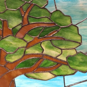 May include: A stained glass window depicting a tree with brown branches and green leaves against a blue sky background.