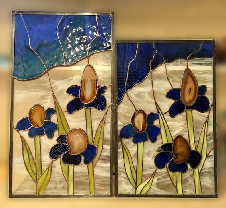 May include: Two stained glass panels depicting blue flowers with brown agate centers. The flowers are set against a background of yellow and white, with a blue sky at the top of the panels.