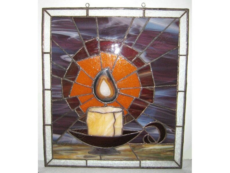 K&ouml;nnte beinhalten: Quadratische Glasmalerei mit einer Kerze in einem Halter. Die Kerze hat eine gelbe Flamme und sitzt in einem dunkelbraunen Halter. Der Hintergrund ist eine Mischung aus orangefarbenem, violettem und blauem Glas mit einem wei&szlig;en Rand.