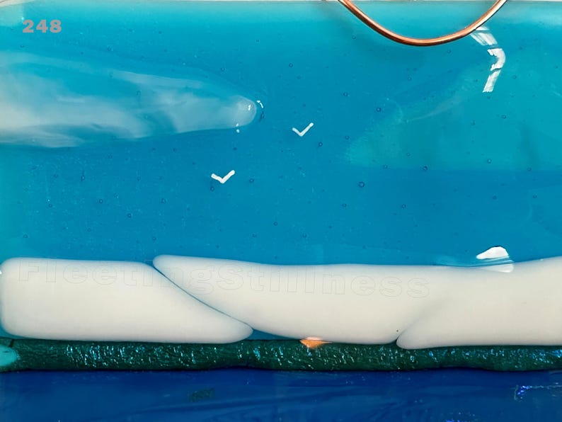 May include: A fused glass art piece featuring a bright blue sky with white clouds and two small white bird silhouettes. The number 248 is printed in the top left corner. A dark green horizontal band sits above a deep blue base section.