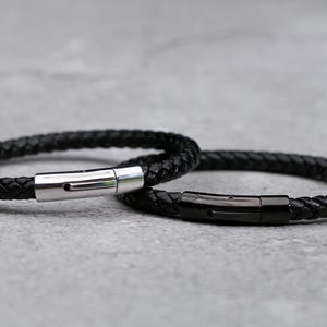 Puede incluir: Dos pulseras de cuero negro con cierres de metal plateado y negro.